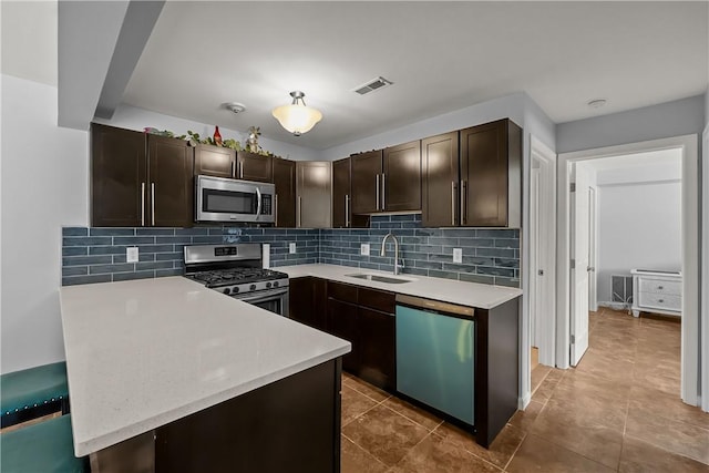 kitchen with tasteful backsplash, sink, dark brown cabinets, and stainless steel appliances