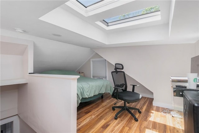 bedroom with a skylight and light hardwood / wood-style flooring