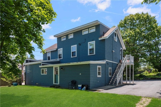 back of property featuring a lawn and a patio