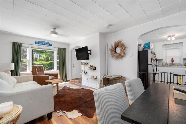 living room featuring crown molding, hardwood / wood-style floors, and ceiling fan