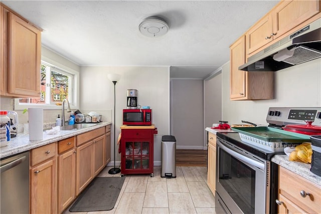 kitchen featuring light tile patterned flooring, appliances with stainless steel finishes, sink, and light stone counters