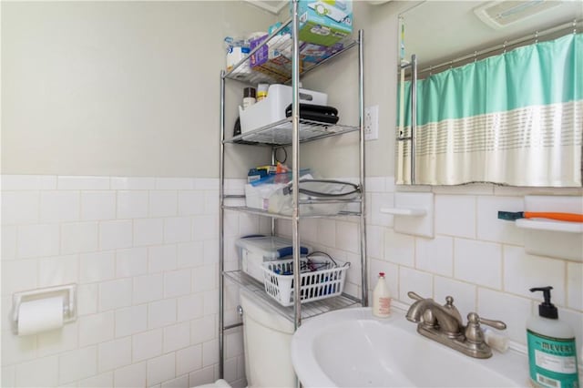 bathroom featuring tile walls, sink, and a shower with curtain