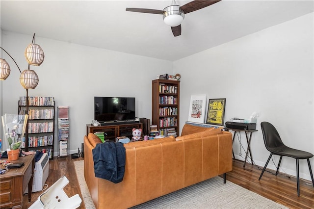 living room with ceiling fan and dark hardwood / wood-style flooring