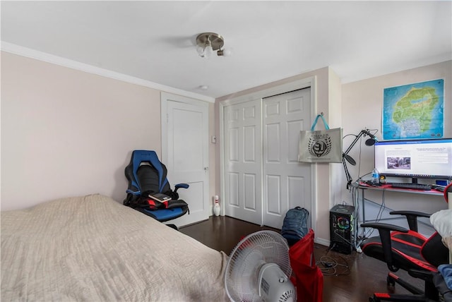 bedroom with dark hardwood / wood-style floors and a closet