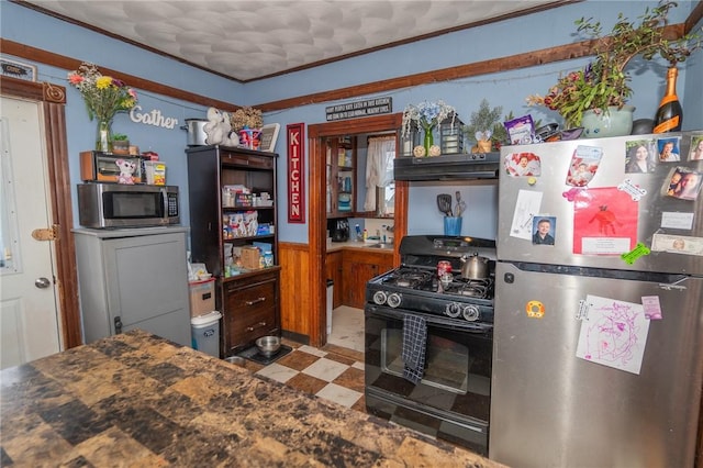 kitchen featuring ornamental molding, wood walls, and appliances with stainless steel finishes