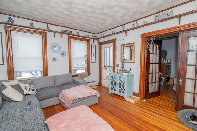 living room featuring a baseboard radiator, hardwood / wood-style floors, and a textured ceiling