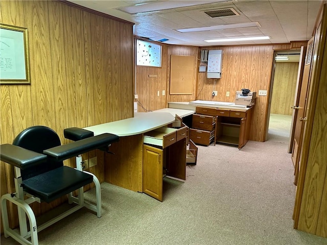 carpeted home office featuring wood walls