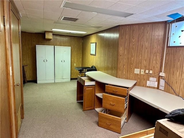 home office with light colored carpet and wood walls