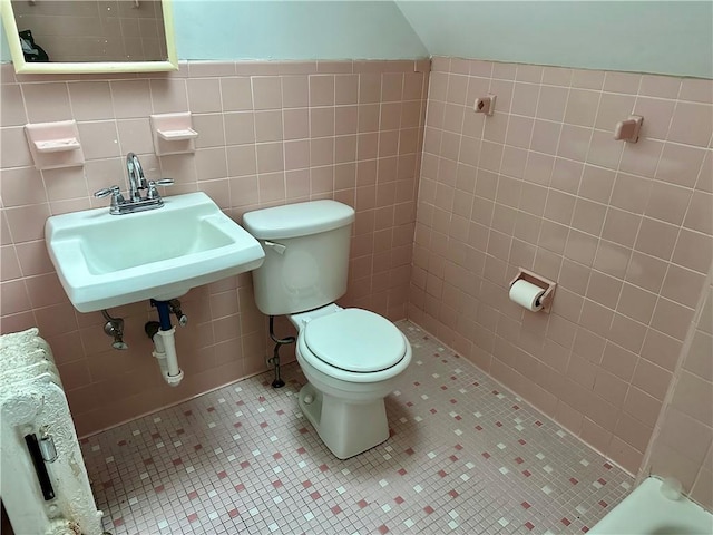 bathroom featuring sink, toilet, tile patterned flooring, and tile walls