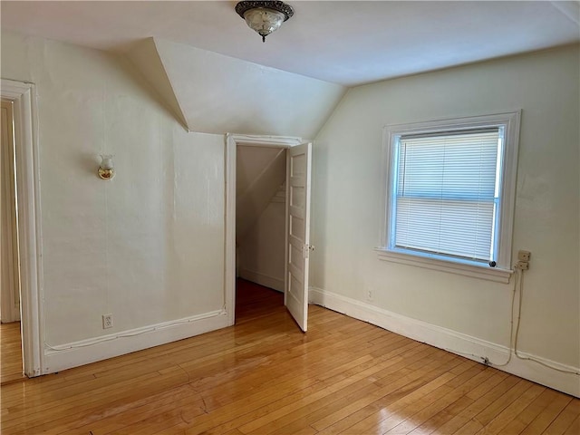 bonus room with vaulted ceiling and light wood-type flooring