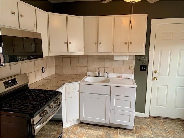 kitchen featuring backsplash, stainless steel appliances, sink, and white cabinets