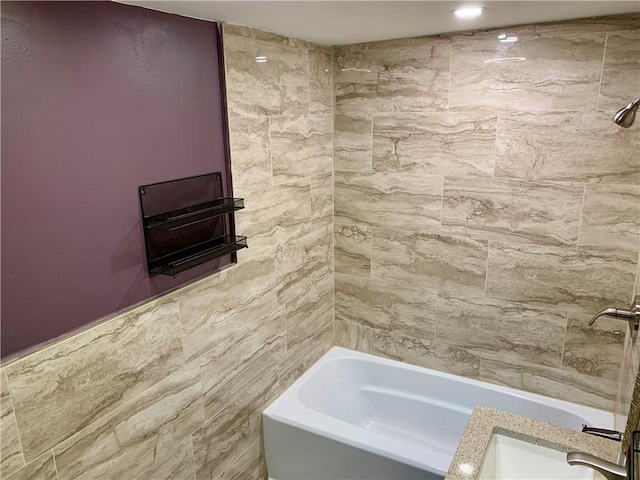 bathroom with tiled shower / bath combo and tile walls