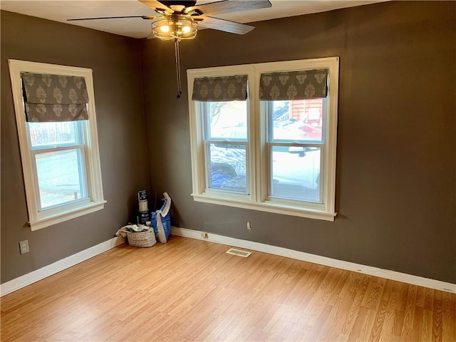 empty room with ceiling fan, light hardwood / wood-style floors, and a wealth of natural light