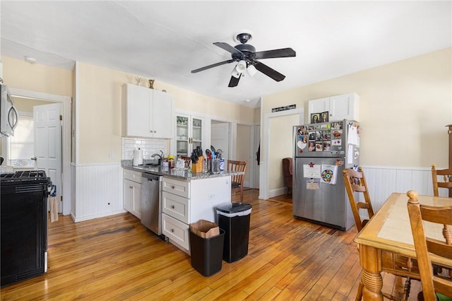 kitchen featuring dark stone countertops, ceiling fan, stainless steel appliances, light hardwood / wood-style floors, and white cabinets