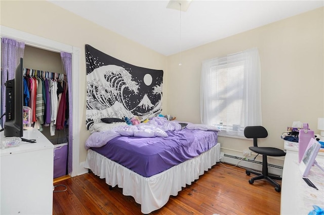 bedroom featuring dark wood-type flooring, a closet, and baseboard heating