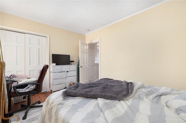 bedroom featuring hardwood / wood-style floors, ornamental molding, and a closet