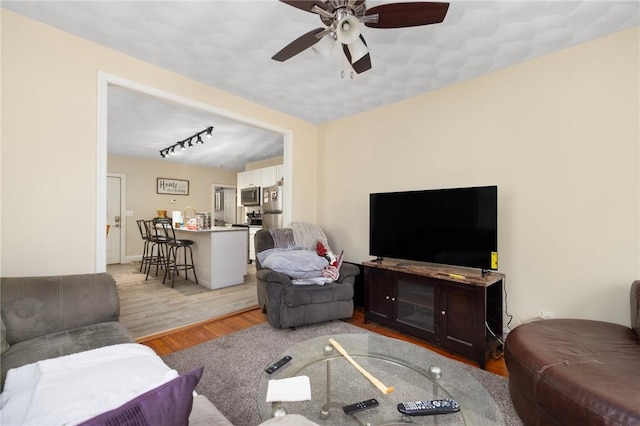 living room with ceiling fan and light hardwood / wood-style flooring