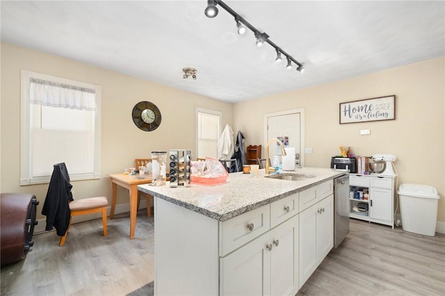 kitchen with white cabinetry, sink, dishwasher, and a center island with sink