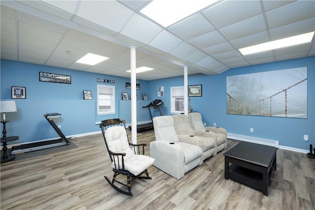 living room with hardwood / wood-style floors, a paneled ceiling, and a baseboard radiator