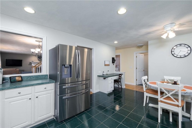 kitchen featuring white cabinetry, ceiling fan with notable chandelier, dark tile patterned flooring, and stainless steel fridge with ice dispenser