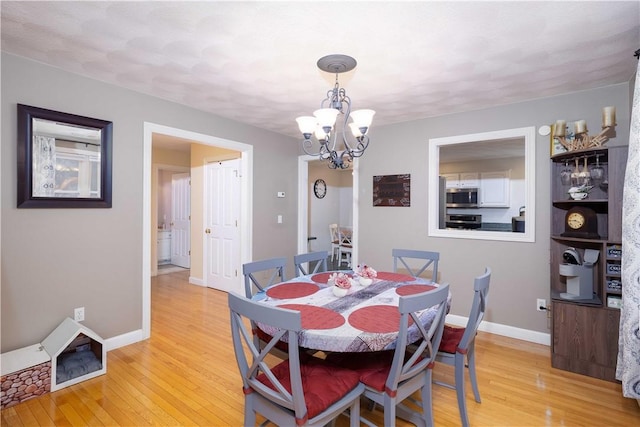 dining room featuring an inviting chandelier and light hardwood / wood-style flooring