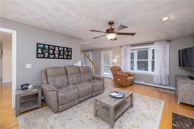 living room featuring a baseboard heating unit, wood-type flooring, and ceiling fan