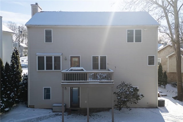 snow covered property with a balcony