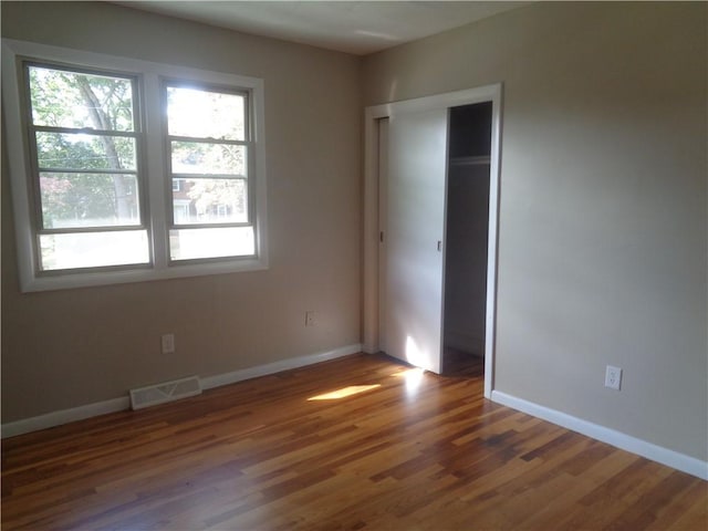 unfurnished bedroom featuring dark wood-type flooring and a closet