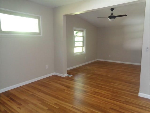 empty room featuring plenty of natural light, hardwood / wood-style floors, and ceiling fan