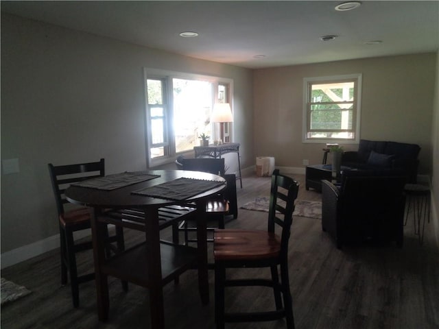 dining space with plenty of natural light and dark hardwood / wood-style flooring