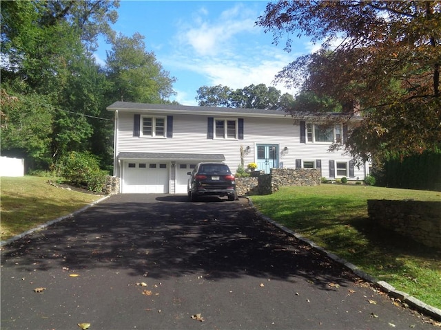 split foyer home featuring a garage and a front lawn