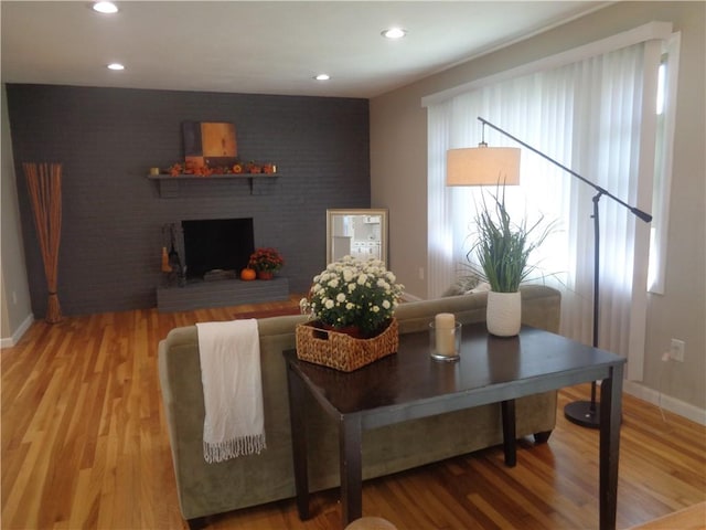 living room featuring hardwood / wood-style flooring and a brick fireplace