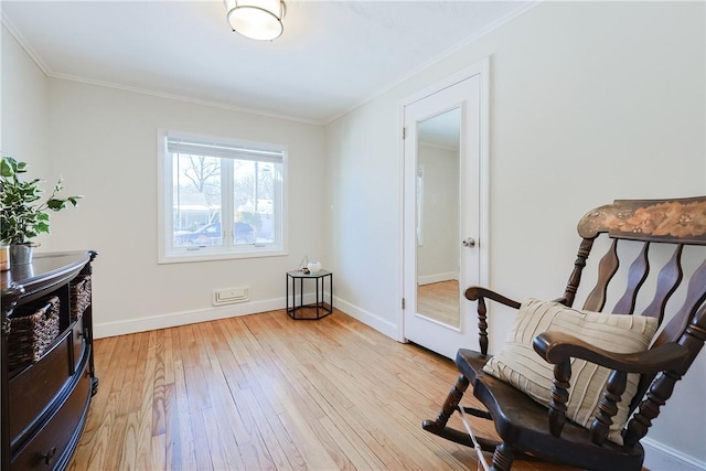 sitting room with crown molding and light hardwood / wood-style floors