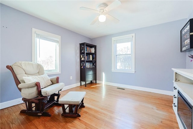 sitting room with ceiling fan and light hardwood / wood-style flooring