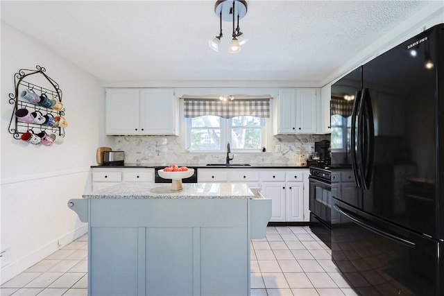 kitchen featuring sink, light tile patterned floors, a center island, black appliances, and white cabinets