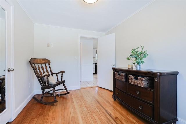 sitting room featuring ornamental molding and light hardwood / wood-style flooring