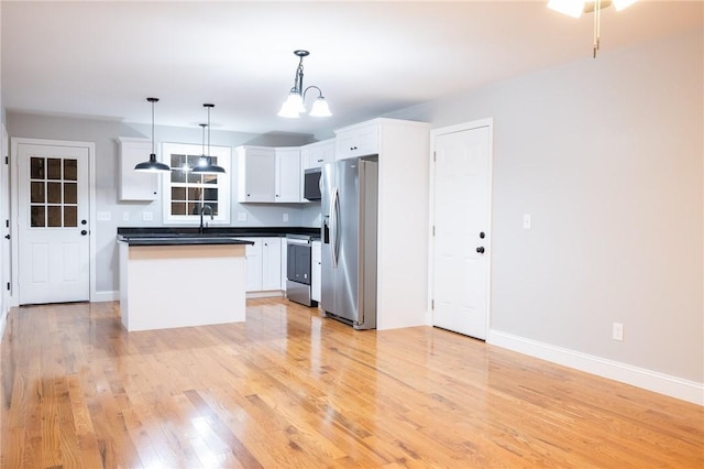 kitchen with decorative light fixtures, a chandelier, stainless steel appliances, light hardwood / wood-style floors, and white cabinets