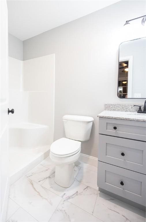 bathroom with vanity, toilet, and a shower