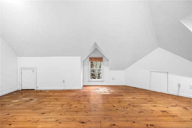 bonus room with vaulted ceiling and light wood-type flooring