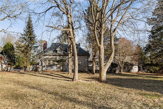 exterior space featuring a chimney and a lawn