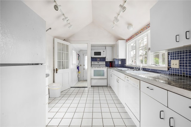 kitchen featuring light tile patterned floors, lofted ceiling, white cabinets, a sink, and white appliances