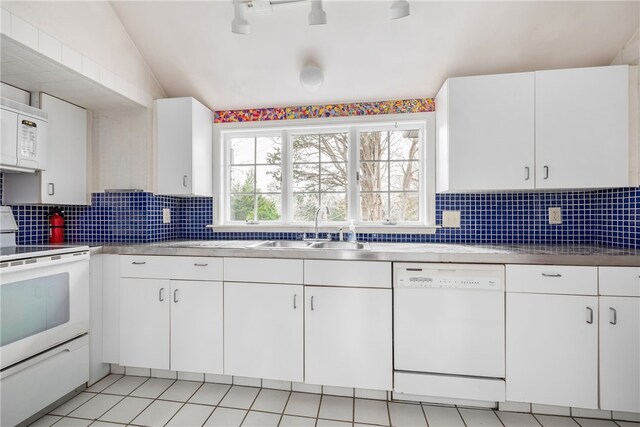 kitchen with white cabinetry, sink, white appliances, and lofted ceiling