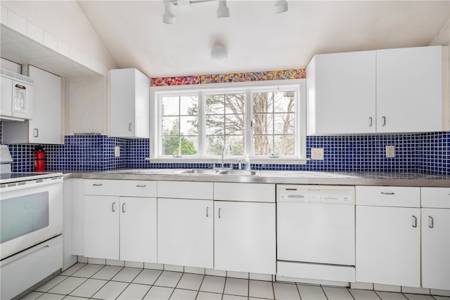 kitchen with a wealth of natural light, lofted ceiling, white appliances, and a sink