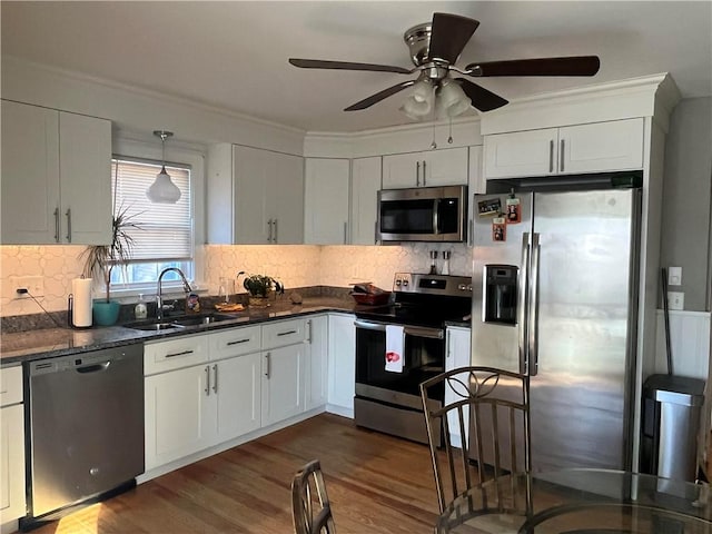 kitchen featuring sink, appliances with stainless steel finishes, white cabinetry, backsplash, and dark hardwood / wood-style floors