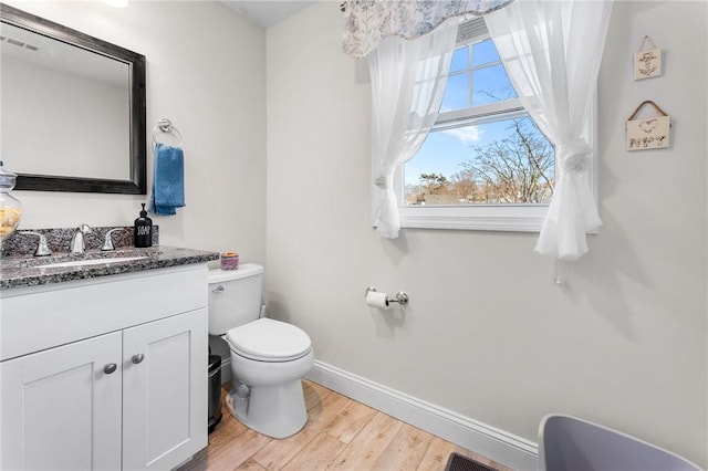 bathroom with vanity, toilet, and hardwood / wood-style floors