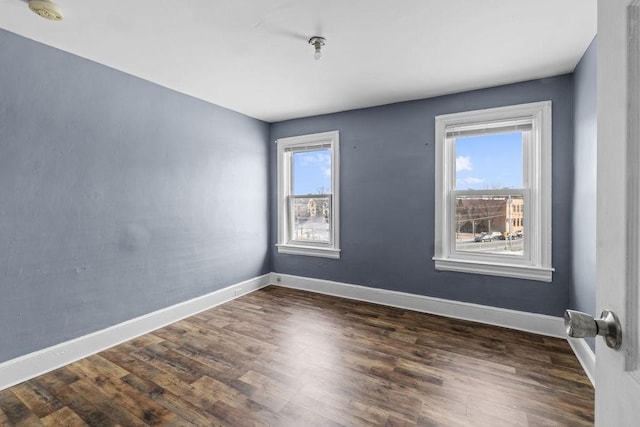 unfurnished room with a healthy amount of sunlight and dark wood-type flooring