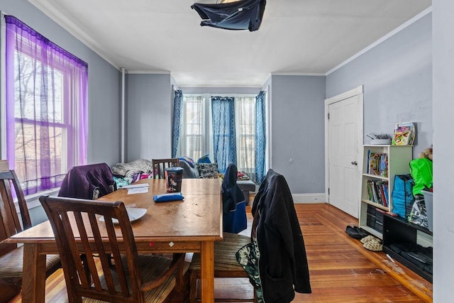 dining area with hardwood / wood-style flooring, crown molding, and a wealth of natural light