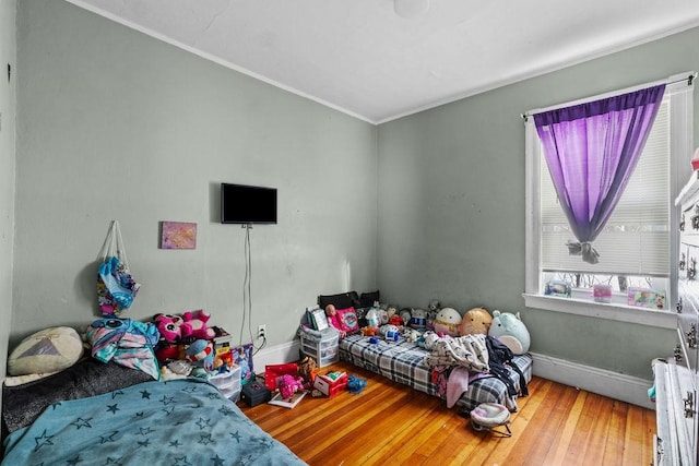 bedroom with hardwood / wood-style flooring and ornamental molding