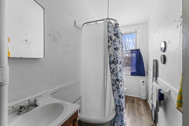 bathroom with hardwood / wood-style flooring, shower / tub combo with curtain, and vanity