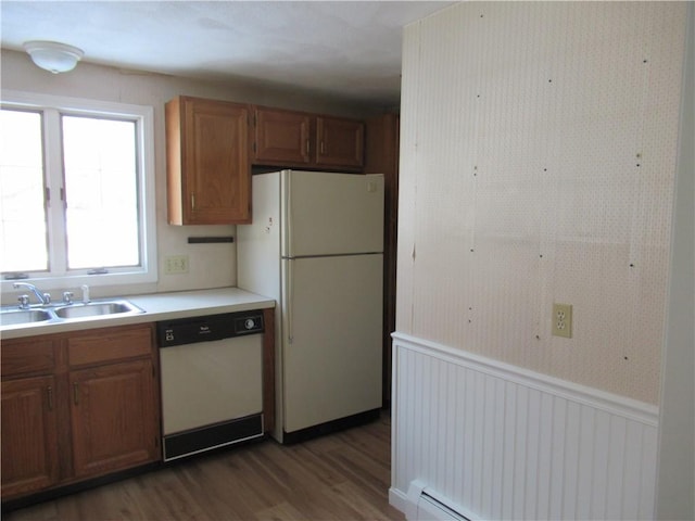 kitchen with white appliances, dark hardwood / wood-style floors, sink, and a baseboard radiator